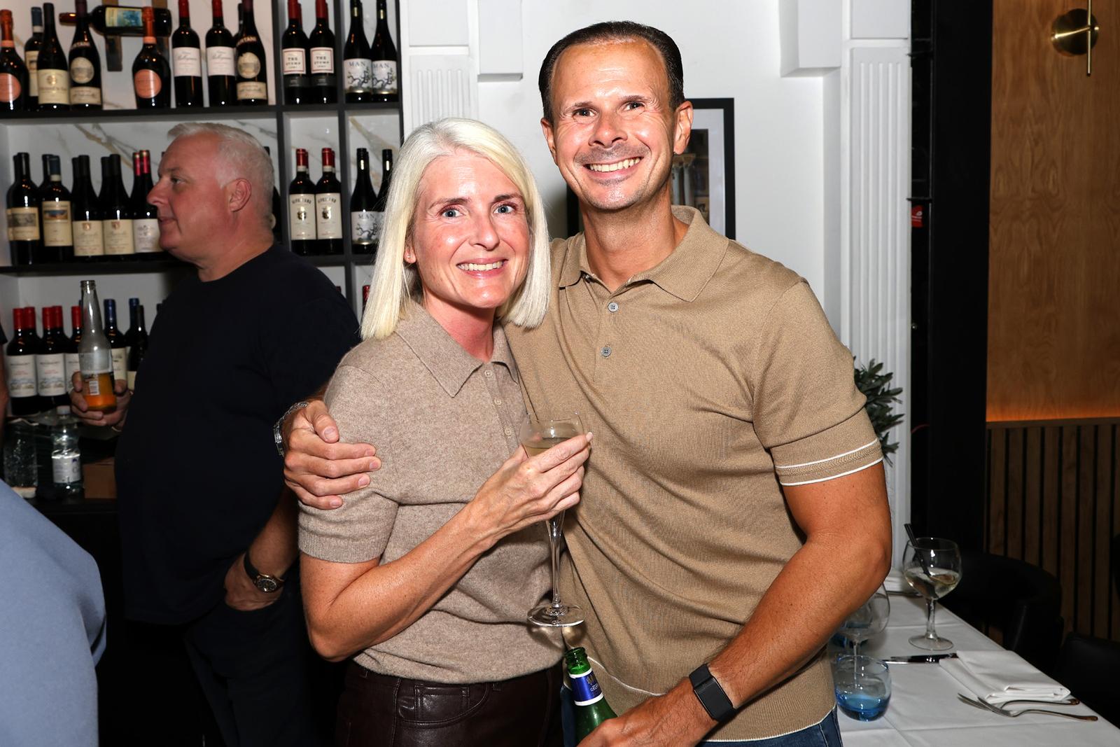 Happy guests by the wine wall