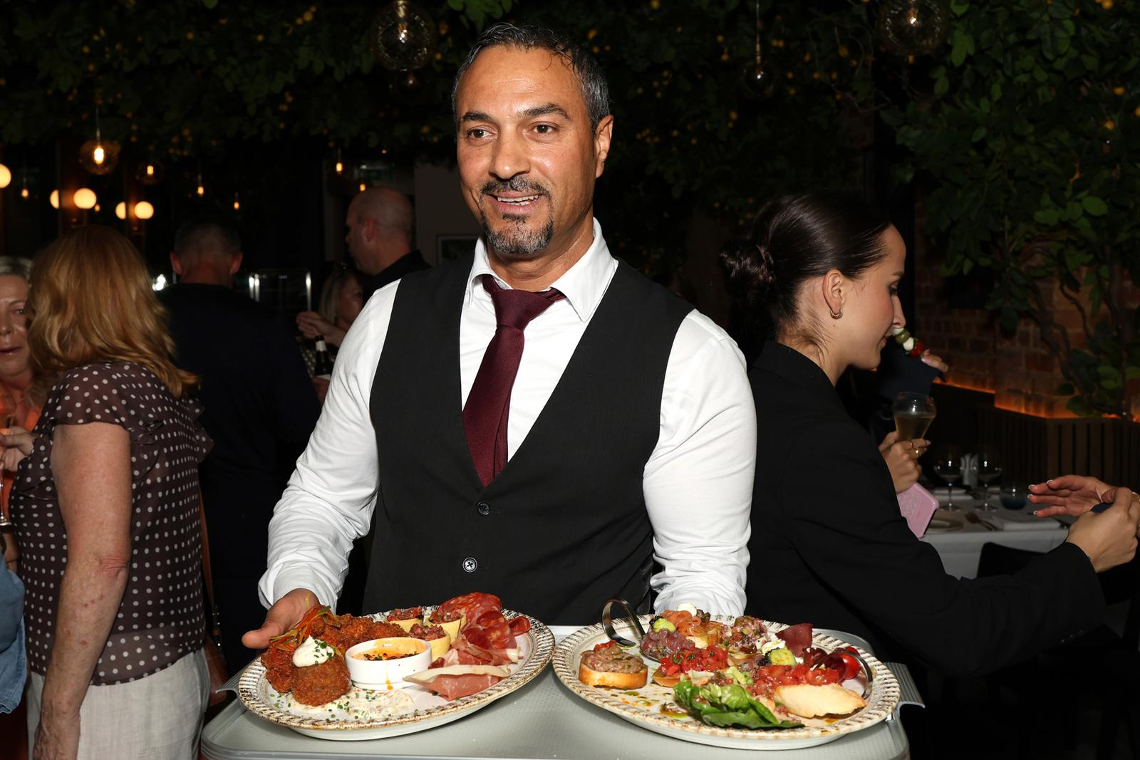 A waiter with platters from the kitchen